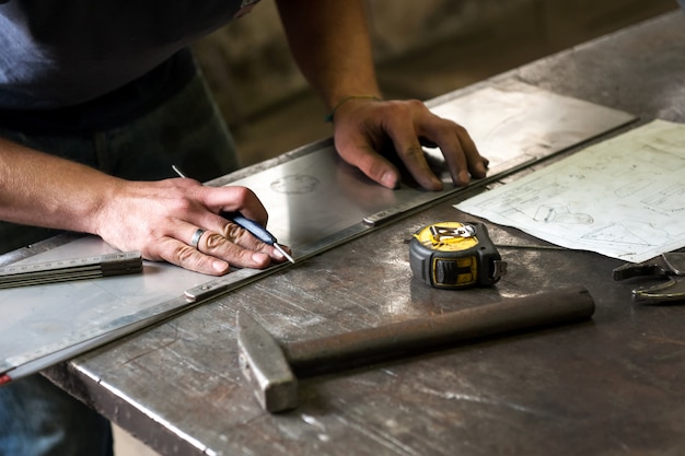 Premium Photo | Metalworker marking measurements on metal