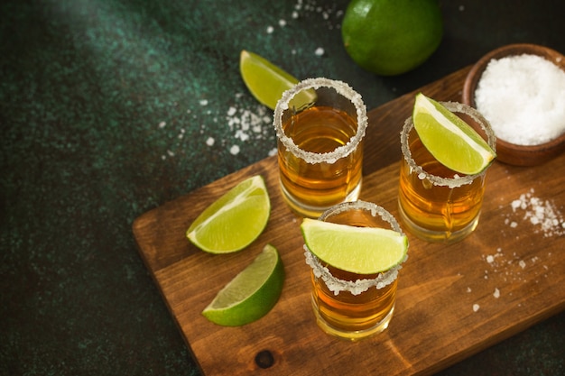 Premium Photo | Mexican gold tequila shot with lime and salt on dark ...
