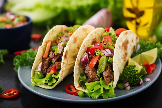 Mexican tacos with beef in tomato sauce and salsa | Free Photo