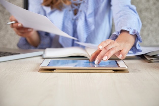 Mid section of unrecognizable woman working with tablet pc at the office desk Free Photo