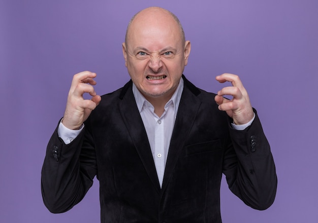middle-aged-bald-man-suit-going-wild-raising-arms-yelling-with-aggressive-expression-standing-purple-wall_141793-61907.jpg