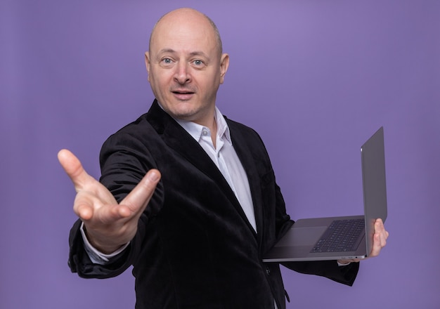 Free Photo Middle Aged Bald Man In Suit Holding Laptop Looking At Camera