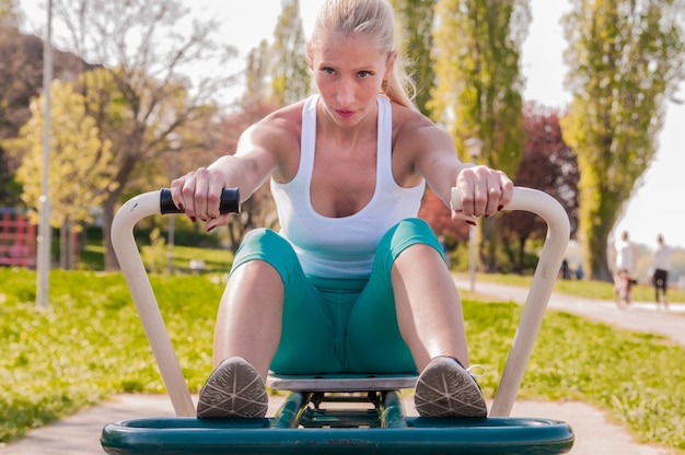 Premium Photo Middle Aged Woman Exercising On Rowing Machine In Park