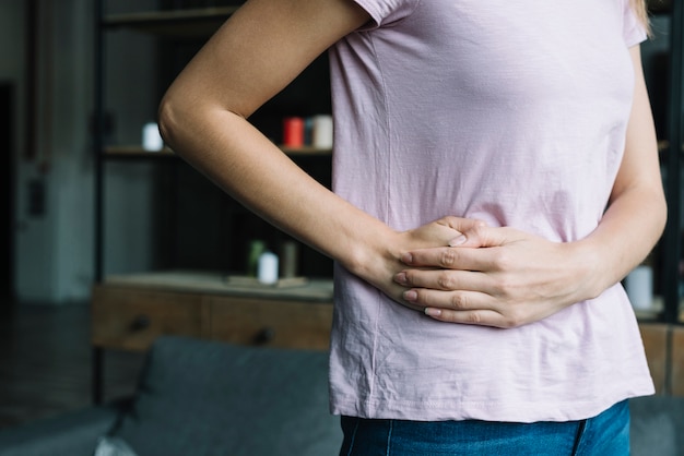 Premium Photo | Midsection view of a woman suffering from waist pain