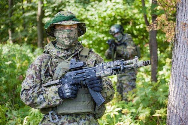 Premium Photo | Military man in camouflage with guns in the woods