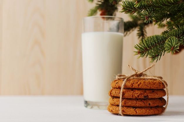 クリスマスツリーの下のサンタクロースのミルクとクッキー プレミアム写真