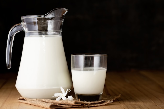 Milk in glass and jug on wooden table Free Photo