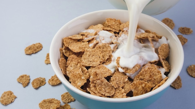 Premium Photo | Milk pouring into bowl with bran flakes, healthy cereal ...