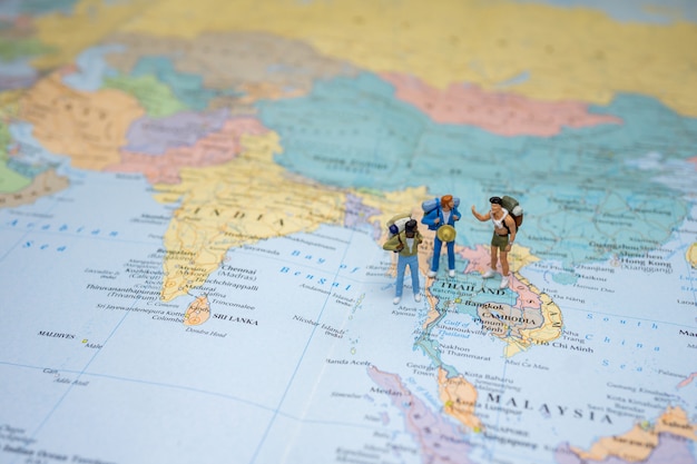 ミニチュア観光客lgbtqが立ち上がって世界地図でタイの地図の上を歩きます プレミアム写真