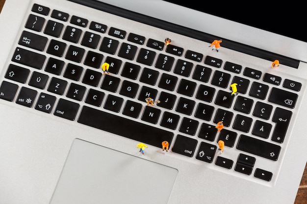 Miniature Workmen Repairing A Laptop Keyboard Photo Free Download