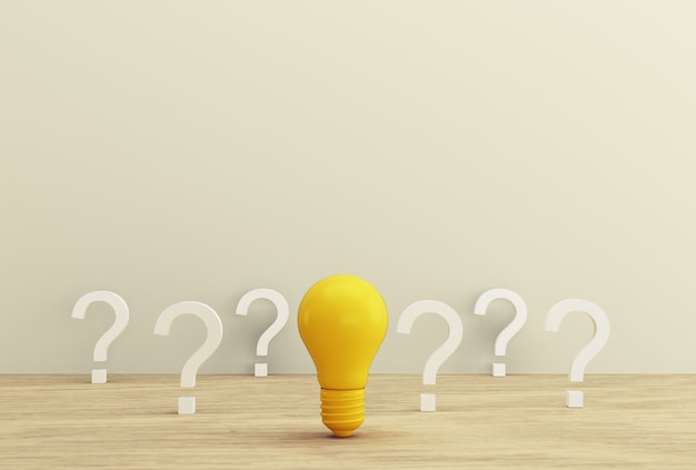 Minimal concept creative idea and innovation. yellow light bulb revealing an idea with question mark on a wood background. Premium Photo