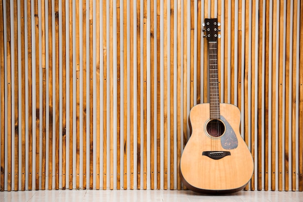 木製の背景にシンプルなアコースティックギター プレミアム写真