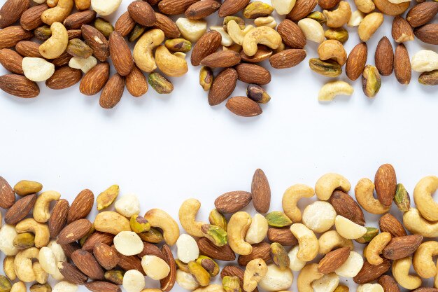 Download Mixed nuts on white background from above, walnut, pistachios, almonds, hazelnuts and cas ...