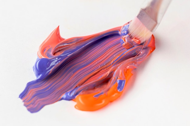 Free Photo | Mixed orange and blue paint with brush