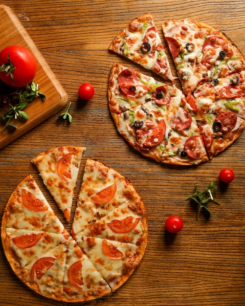 Mixed pizza with sausage and pizza with cheese and tomatoes Free Photo