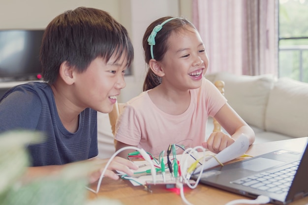 Mixed race young asian children having fun learning coding together, learning remotely at home, stem science, homeschooling education, social distancing, isolation concept Premium Photo