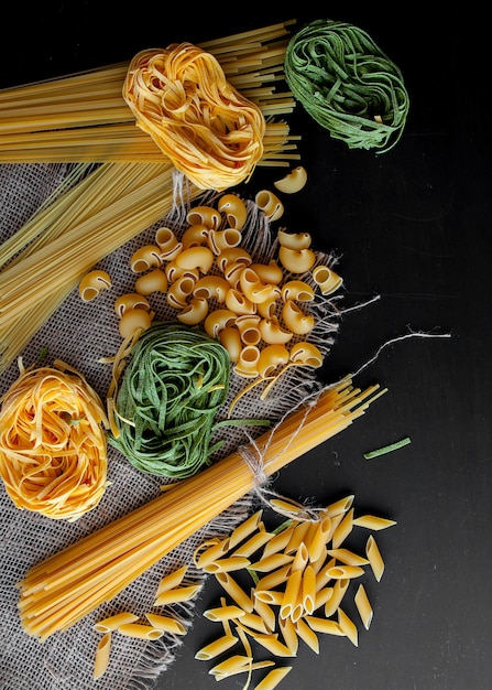 Premium Photo | Mixed raw pasta on black background