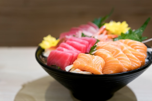 Premium Photo | Mixed sliced fish sashimi on ice in black bowl. sashimi ...