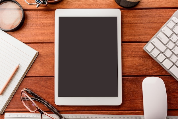 Download Mockup tablet similar to ipad style on wood desk. empty display.keyboard and office stuff ...