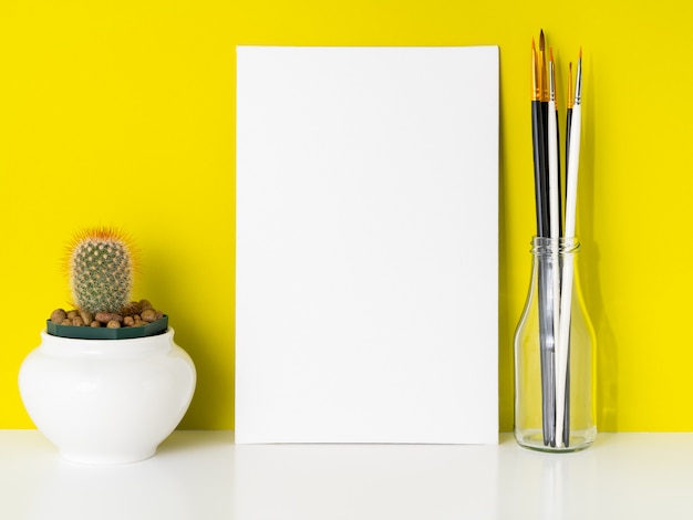 Download Mockup with clean white canvas, cactus, brushes on bright yellow background. concept for c ...