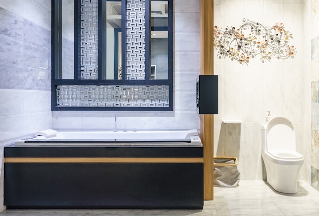 Modern bathroom interior with minimalistic shower and lighting, white toilet, sink and bathtub Premium Photo
