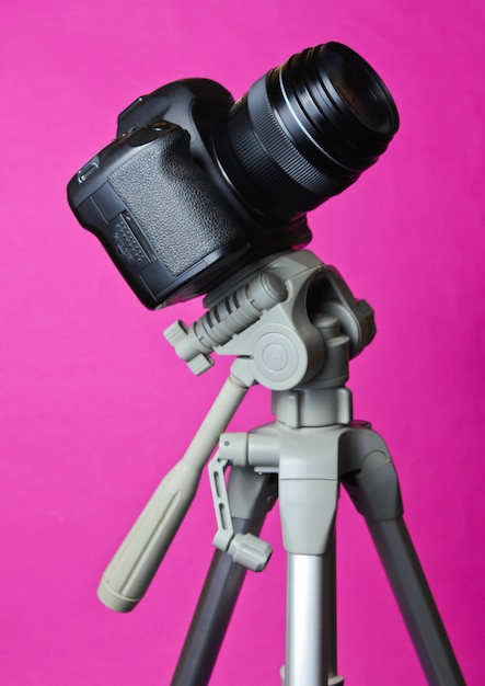 Premium Photo | Modern digital camera with a tripod on pink table ...