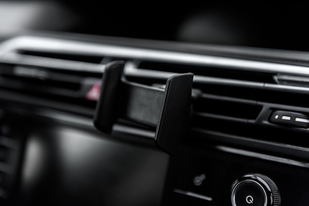 車のダッシュボードの電話ホルダーに取り付けられた最新のスマートフォンデバイスガジェット プレミアム写真