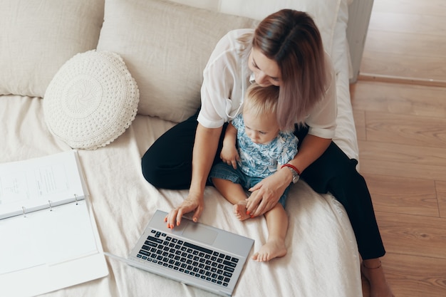 Modern woman working with child. multi-tasking, freelance and motherhood concept Free Photo