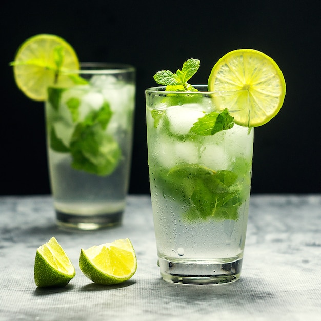 Premium Photo Mojito cocktail with lime and mint in glass on a grey