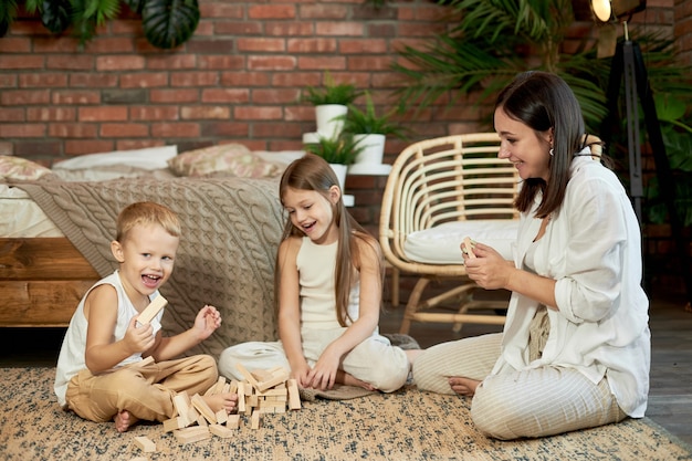 Mama I Deti Igrayut V Skvirl Dzhenga Tauer Zhenshina Devochka I Malchik Igrayut V Semejnuyu Igru Golovolomku Semejnyj Vyhodnoj Premium Foto