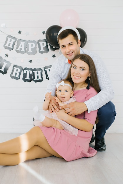 Premium Photo Mom Dad And One Year Old Girl In The Photo Zone For The First Birthday Of The Baby Portrait Of A Happy Young Family