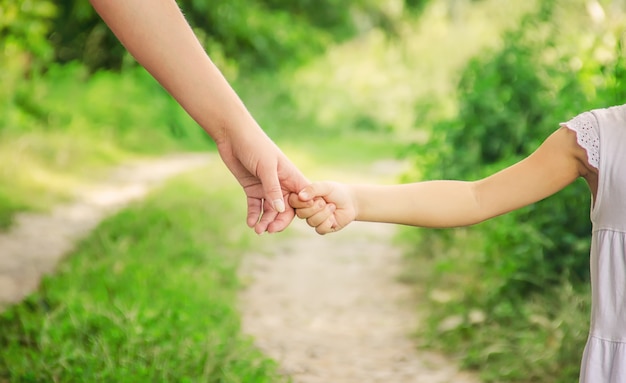 Download Mom and daughter are walking along the road holding hands ...