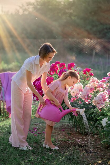 Premium Photo Mom And Daughter Take Care Of Flowers In The Garden