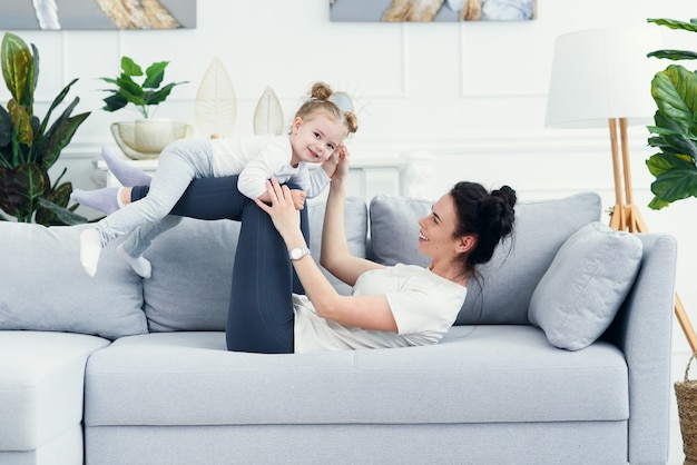 Premium Photo | Mom and her daughter lying on the couch in the living room.