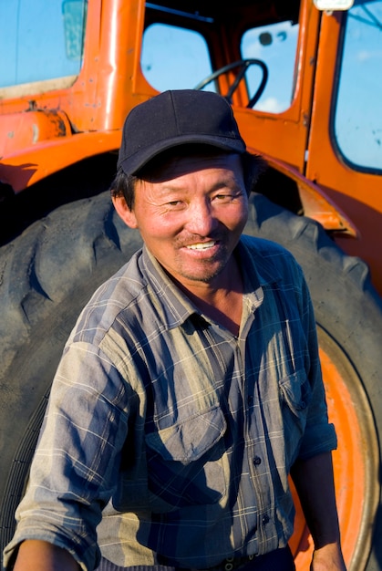 Premium Photo | Mongolian farmer standing in front of his tractor ...