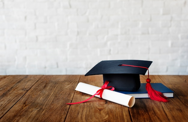 Mortar board and a graduation diploma Free Photo