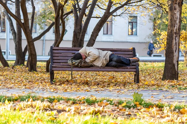 Premium Photo Moscow Russia Homeless Man Sleeping On A Bench In The Park In Autumn