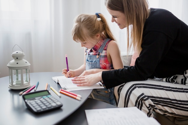 Mother and daughter doing homework together Free Photo