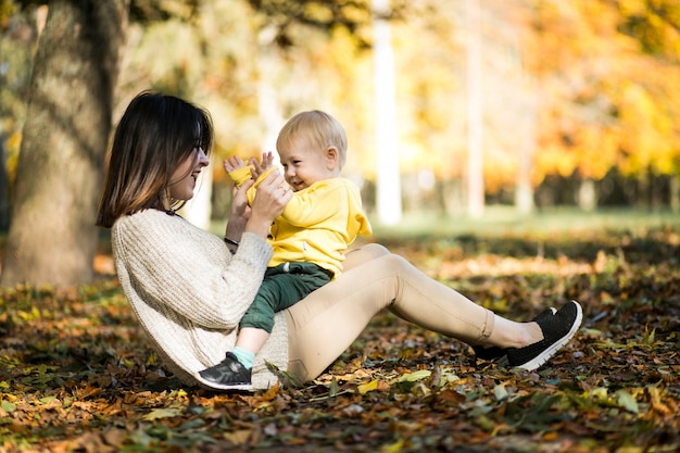 Mother and son in autumn park Free Photo