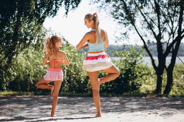 Free Photo | Mother and daughter at the beach practicing yoga