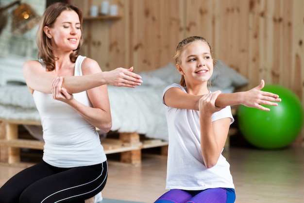 Free Photo | Mother and daughter stretching arms