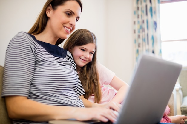 Free Photo | Mother and daughter using laptop in living room