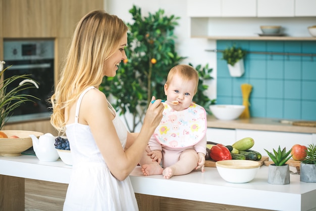 Mother Feeding Her Baby Girl With A Spoon Mother Giving Food To Her