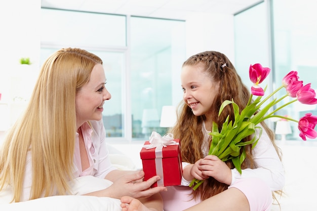 Mother giving her daughter a gift Photo | Free Download