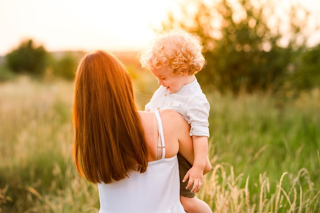 Premium Photo | Mother holding son in her arms back view