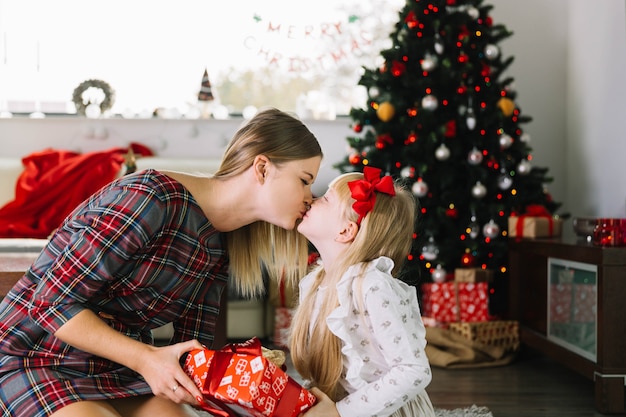 Free Photo Mother Kissing Her Daughter At Christmas 