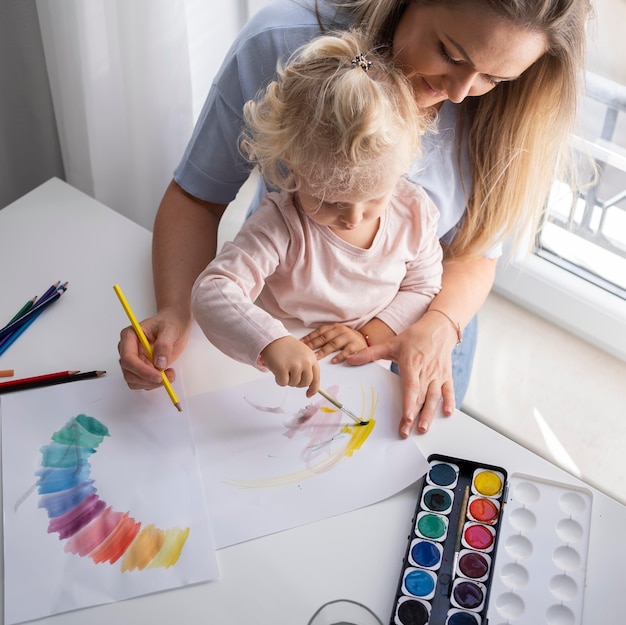 家で子供と一緒に絵を描く母 無料の写真