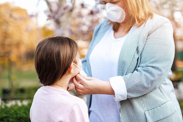 Download Premium Photo | Mother placing protective mask on face of ...