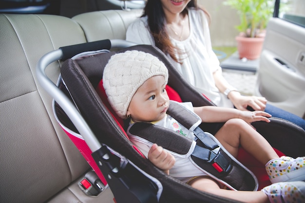 Premium Photo | Mother securing her baby in the car seat in her car