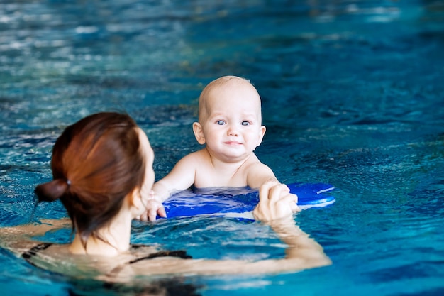 Premium Photo | Mother teaching baby to swim portrait of charming 11 ...